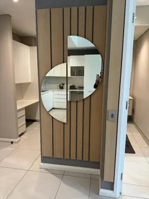 a circular mirror on a wooden wall in a kitchen at Modern holiday home in Pretoria