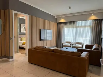 a living room with a couch and a television at Modern holiday home in Pretoria