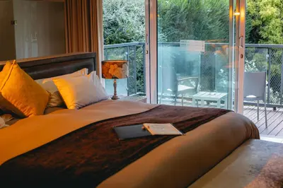 a bedroom with a bed with a view of a balcony at Highveld Splendour Boutique Bed and Breakfast in Ermelo