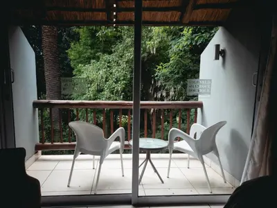 two chairs and a table on a balcony at Highveld Splendour Boutique Bed and Breakfast in Ermelo