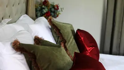 a pile of pillows sitting on a bed at La Villa Spa in Nelspruit