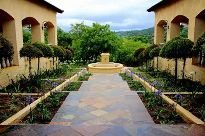 a garden with a fountain in the middle of a building at La Villa Spa in Nelspruit