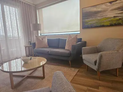 a living room with a couch and chairs and a table at 514 at The Regency in Pretoria