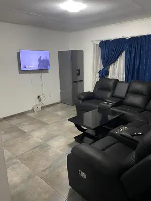 a living room with couches and a flat screen tv at AM'S place in Kempton Park