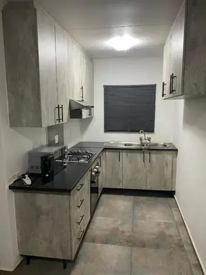 a small kitchen with a sink and a microwave at AM'S place in Kempton Park