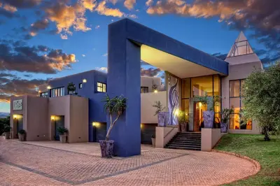 a house with a blue facade with a church at The Links Guest House in Pretoria