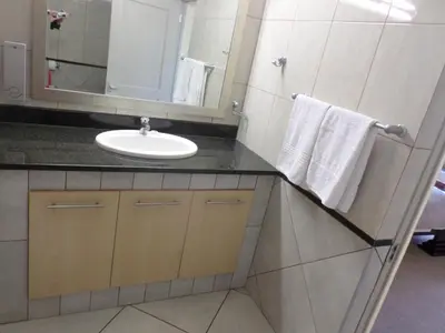 a bathroom with a sink and a mirror at The Links Guest House in Pretoria