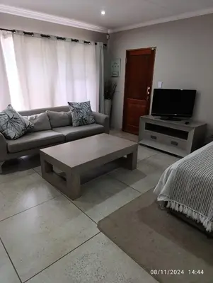 a living room with a couch and a tv at Studio S Class and Comfort in Pretoria