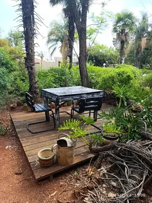 a picnic table and bench on a wooden deck with plants at Studio S Class and Comfort in Pretoria