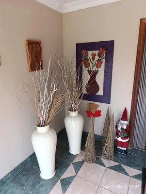 three white vases sitting on a tiled floor at Studio S Class and Comfort in Pretoria