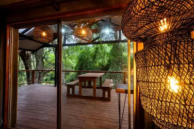 a screened in porch with a table and a window at Matumi Trail Forest Lodges - Matumi and Mitzeeri in Tzaneen
