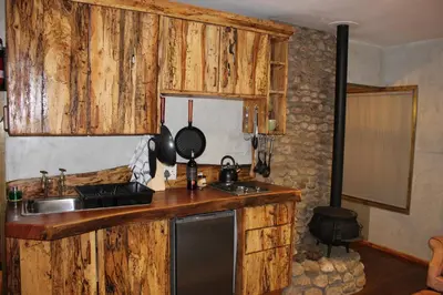 a kitchen with wooden cabinets and a sink and a counter top at Matumi Trail Forest Lodges - Matumi and Mitzeeri in Tzaneen