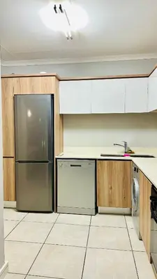 a kitchen with white cabinets and a stainless steel refrigerator at Bookings At The Blyde Crystal Lagoon in Pretoria
