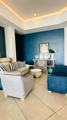 a living room with couches and a blue wall at Bookings At The Blyde Crystal Lagoon in Pretoria