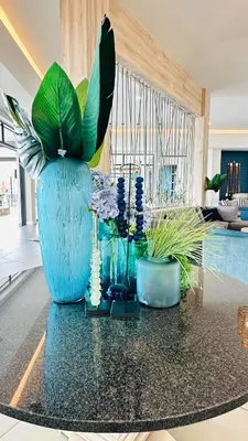 a large blue vase with flowers and plants on a table at Bookings At The Blyde Crystal Lagoon in Pretoria