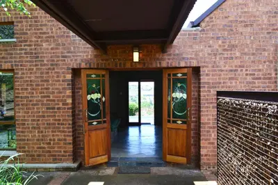 a brick building with wooden doors and a brick wall at 22 on Ridgeway in Dullstroom