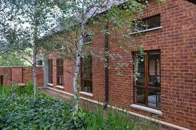 a brick building with a small tree in front of it at 22 on Ridgeway in Dullstroom