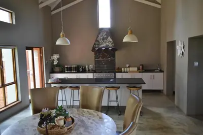 a kitchen with a table and chairs and a counter at 22 on Ridgeway in Dullstroom