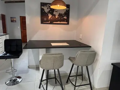 a kitchen with a black counter and two stools at Royal On Olifant Drive in Marloth Park