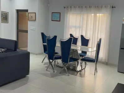 a living room with a table and blue chairs at Royal On Olifant Drive in Marloth Park