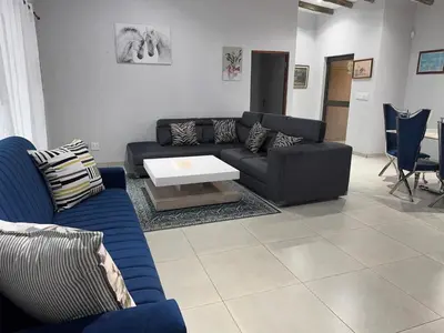 a living room with a couch and a table at Royal On Olifant Drive in Marloth Park