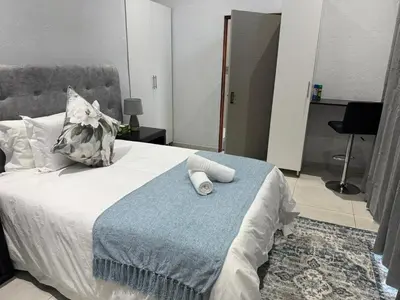 a bedroom with a bed with a blue blanket at Royal On Olifant Drive in Marloth Park