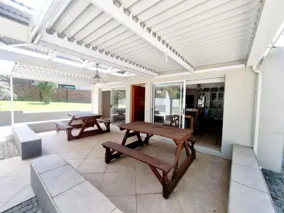 a patio with a wooden table and benches on it at Spindermolen in Dullstroom