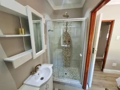 a bathroom with a shower and a sink at Spindermolen in Dullstroom
