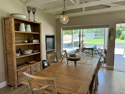 a dining room with a wooden table and chairs at Spindermolen in Dullstroom