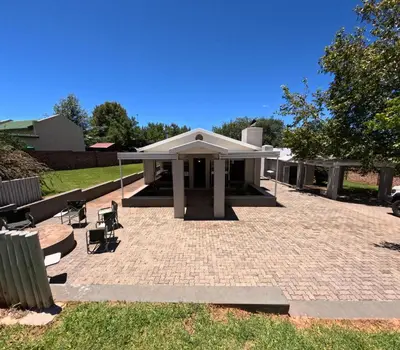 a pavilion with a table and chairs on a patio at Spindermolen in Dullstroom