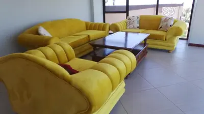 a living room with yellow couches and a coffee table at Amatolo view in Erasmus