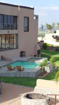 a building with a swimming pool in front of a house at Amatolo view in Erasmus