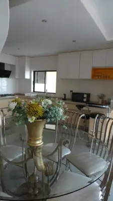 a glass table with chairs and a vase with flowers on it at Amatolo view in Erasmus