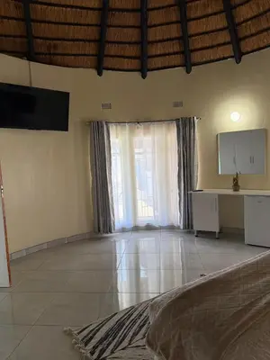 a large living room with a large window and a television at CMK Lodge in Hartbeespoort