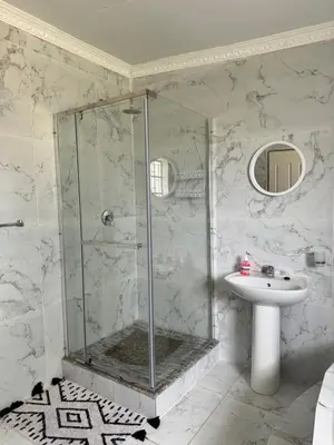 a bathroom with a shower and a sink at CMK Lodge in Hartbeespoort