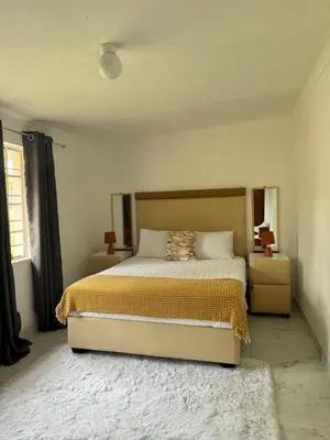 a bedroom with a large bed with a yellow blanket at CMK Lodge in Hartbeespoort