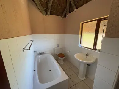 a bathroom with a tub and a toilet and a sink at VM Guesthouse in Hazyview