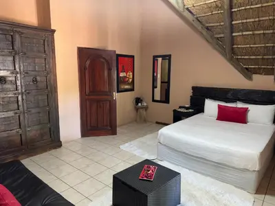 a bedroom with a white bed and a wooden cabinet at VM Guesthouse in Hazyview