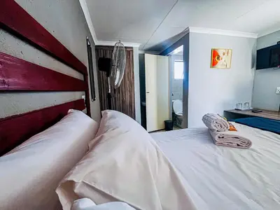 two beds in a bedroom with an american flag headboard at Dingwako Lodge in Mokopane