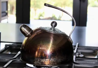 a copper tea kettle sitting on a stove at Ziziphus River Lodge in Hectorspruit