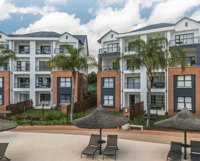a row of apartment buildings with chairs and palm trees at The Blyde Paradise Luxury 1 Bed in Pretoria