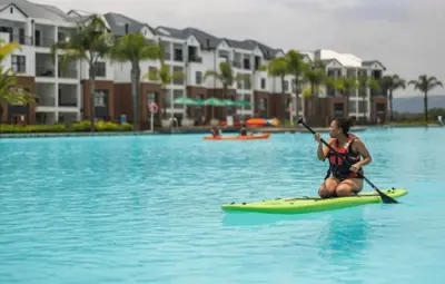 a woman on a paddle board in the water at The Blyde Paradise Luxury 1 Bed in Pretoria