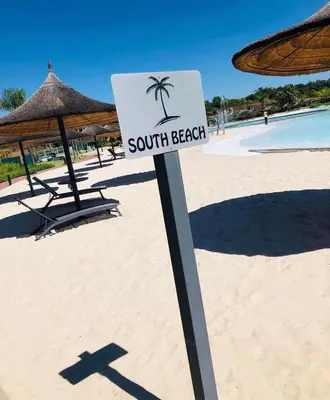 a sign on a beach with a palm tree at The Blyde Paradise Luxury 1 Bed in Pretoria