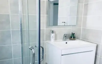 a bathroom with a sink and a shower with a mirror at The Blyde Paradise Luxury 1 Bed in Pretoria