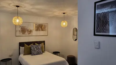 a bedroom with two lights and a bed in it at Villa Tlhago Lodge in Ga-Mothapo