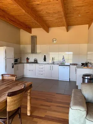 a kitchen with white cabinets and a wooden ceiling at Forestiva Farm - Mountain Retreat in Centurion