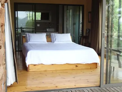 a bedroom with a large bed in a room at Forestiva Farm - Mountain Retreat in Centurion