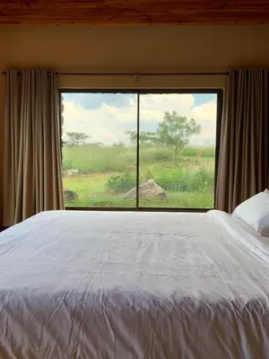 a bedroom with a bed and a large window at Forestiva Farm - Mountain Retreat in Centurion
