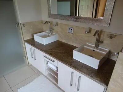 a bathroom with two sinks and a mirror at Forestiva Farm - Mountain Retreat in Centurion