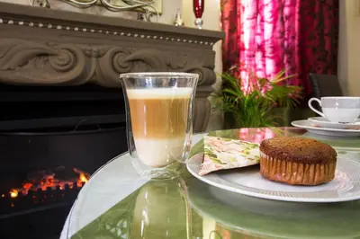 a glass of milk and a muffin on a table with a drink at The Royal Palm B&B in Ohrigstad